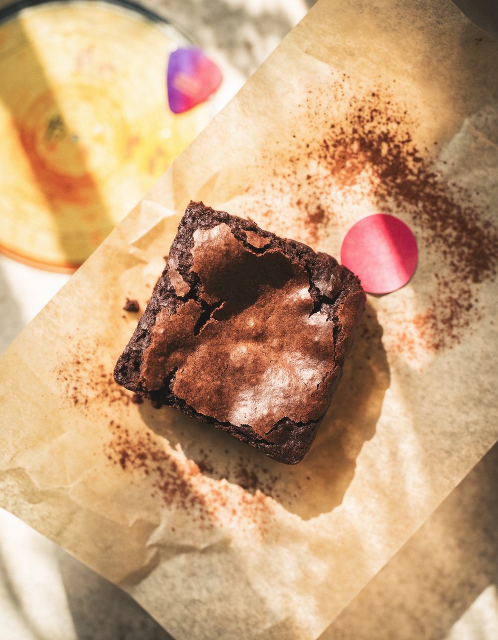 A Melody Bakes brownie on parchment in warm light