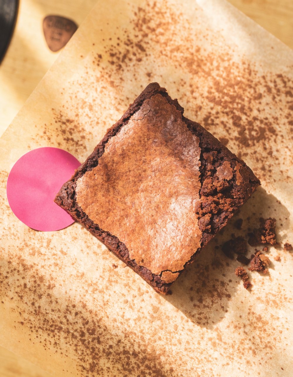 A Melody Bakes brownie shot with a guitar pick and a record