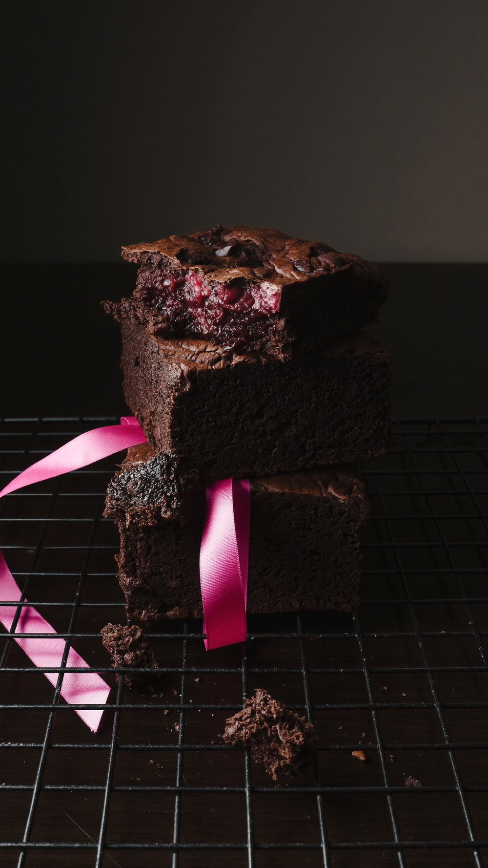 Melody Bakes brownies stacked on a cooling rack with a pink ribbon